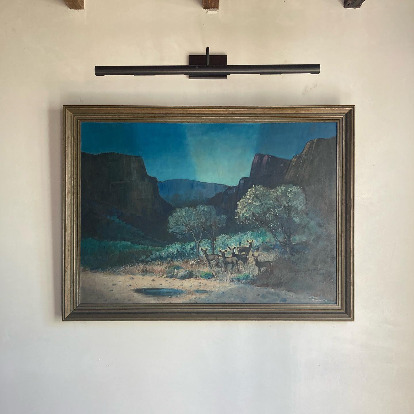 Western American art oil on canvasboard canyon scene with mountain range and a herd of deer at twilight, by Johnson, dated 1967