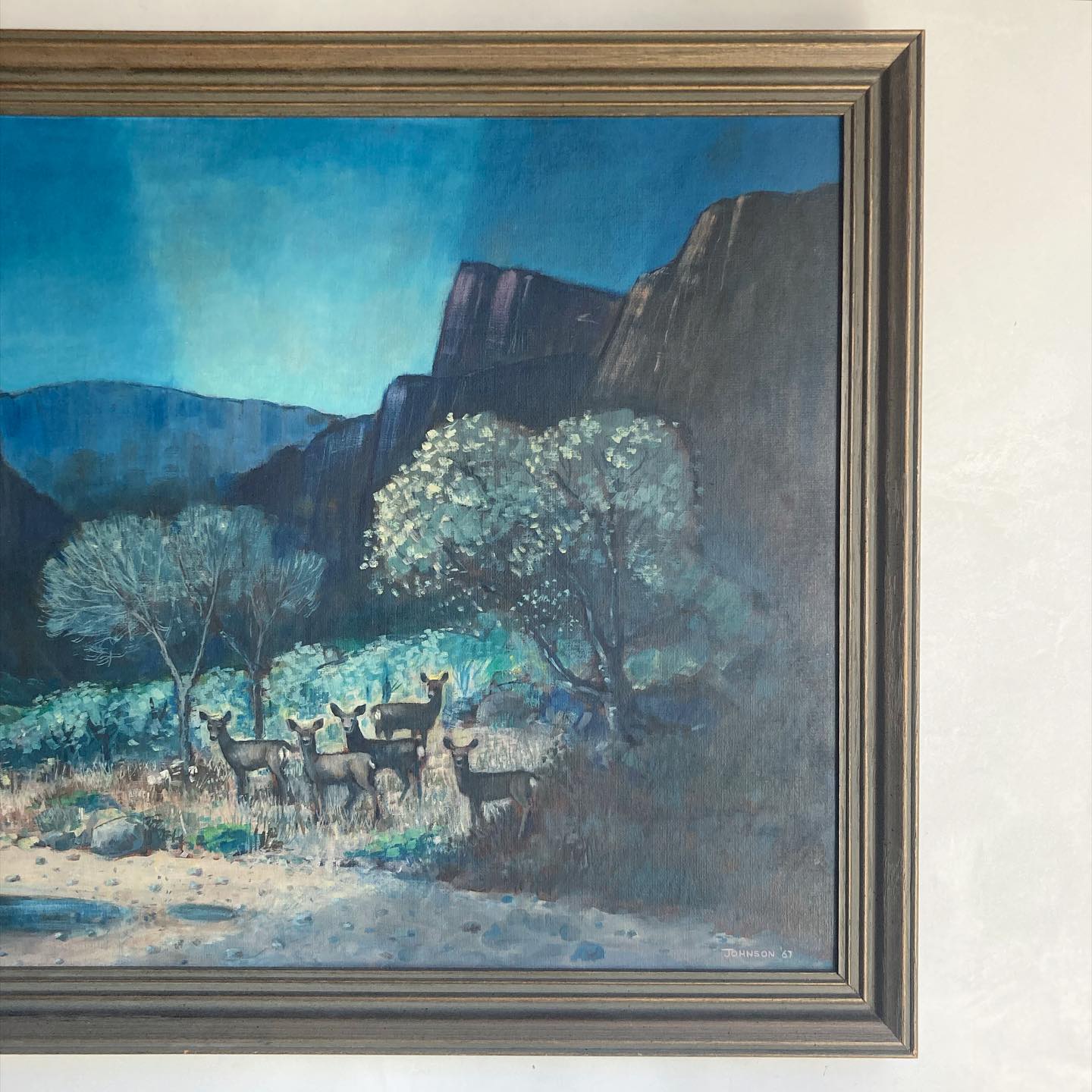 Western American art oil on canvasboard canyon scene with mountain range and a herd of deer at twilight, by Johnson, dated 1967