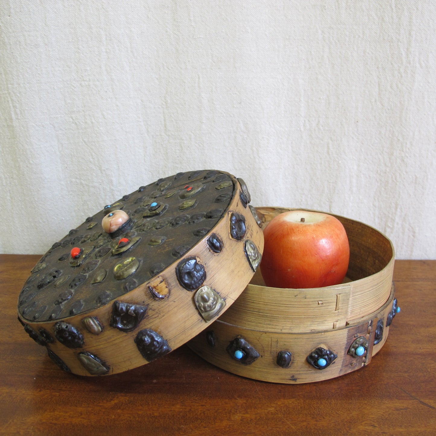 19th century Tibetan Buddhist bentwood box with applied brass relief panels (skulls, seated Buddhas) and glass representing turquoise and coral